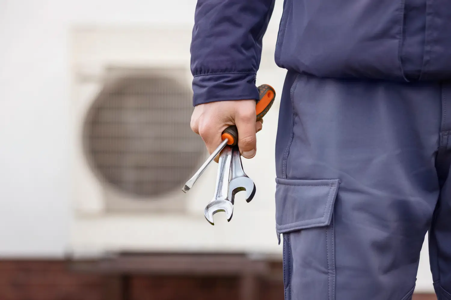 Technician holding tools near unit